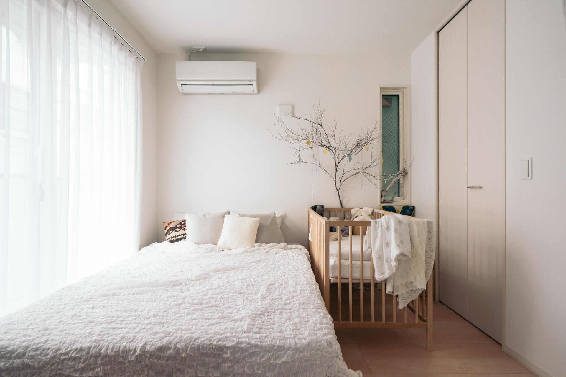 6ヶ月の息子さんと暮らすKatsuraさんの寝室、大きな面積を占める布モノは白やグレーで統一して、とても明るく清潔な雰囲気。（このお部屋はこちら）