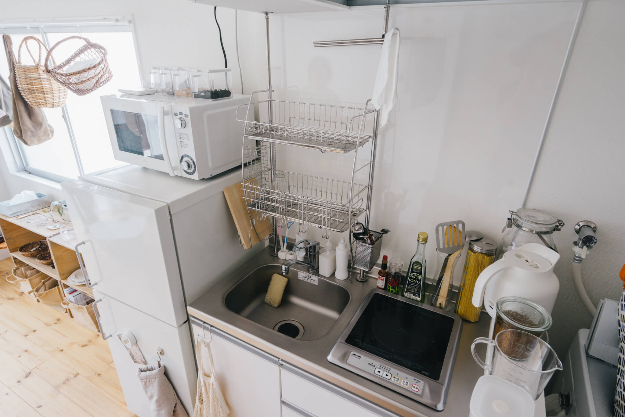 （キャプション） IHの1口キッチン。洗った食器の置き場は、突っ張りタイプの水切り棚を設置することで解決。