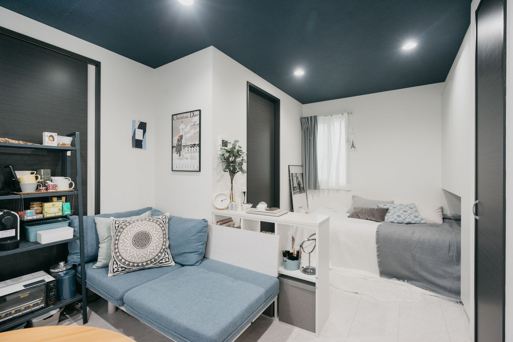 床は白、天井はダークブルー、建具はブラックとメリハリある配色が特徴のデザイナーズのお部屋。合わせる家具も、ブルーやグレーを選んだことで全体に調和し整った雰囲気のお部屋に。