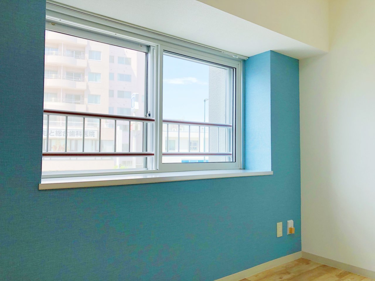 目の覚めるような鮮やかなブルーの壁紙が印象的な、1DKのお部屋。