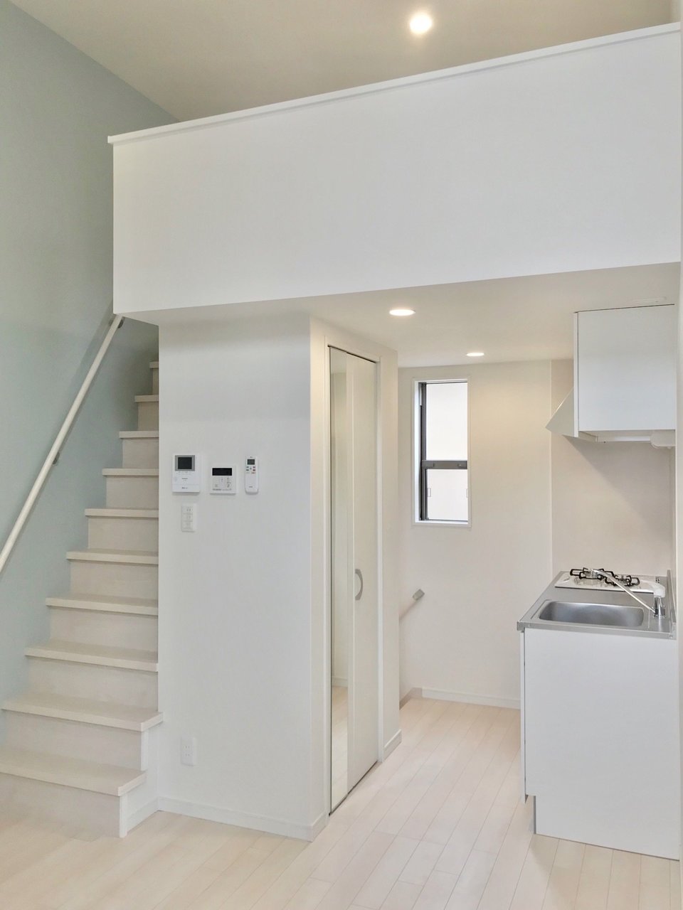 2階はシンプルな6.4畳の空間です。白いキッチン、白い床、それにブルーグレーの壁紙がよく映える。天井が高いのもいいですね。