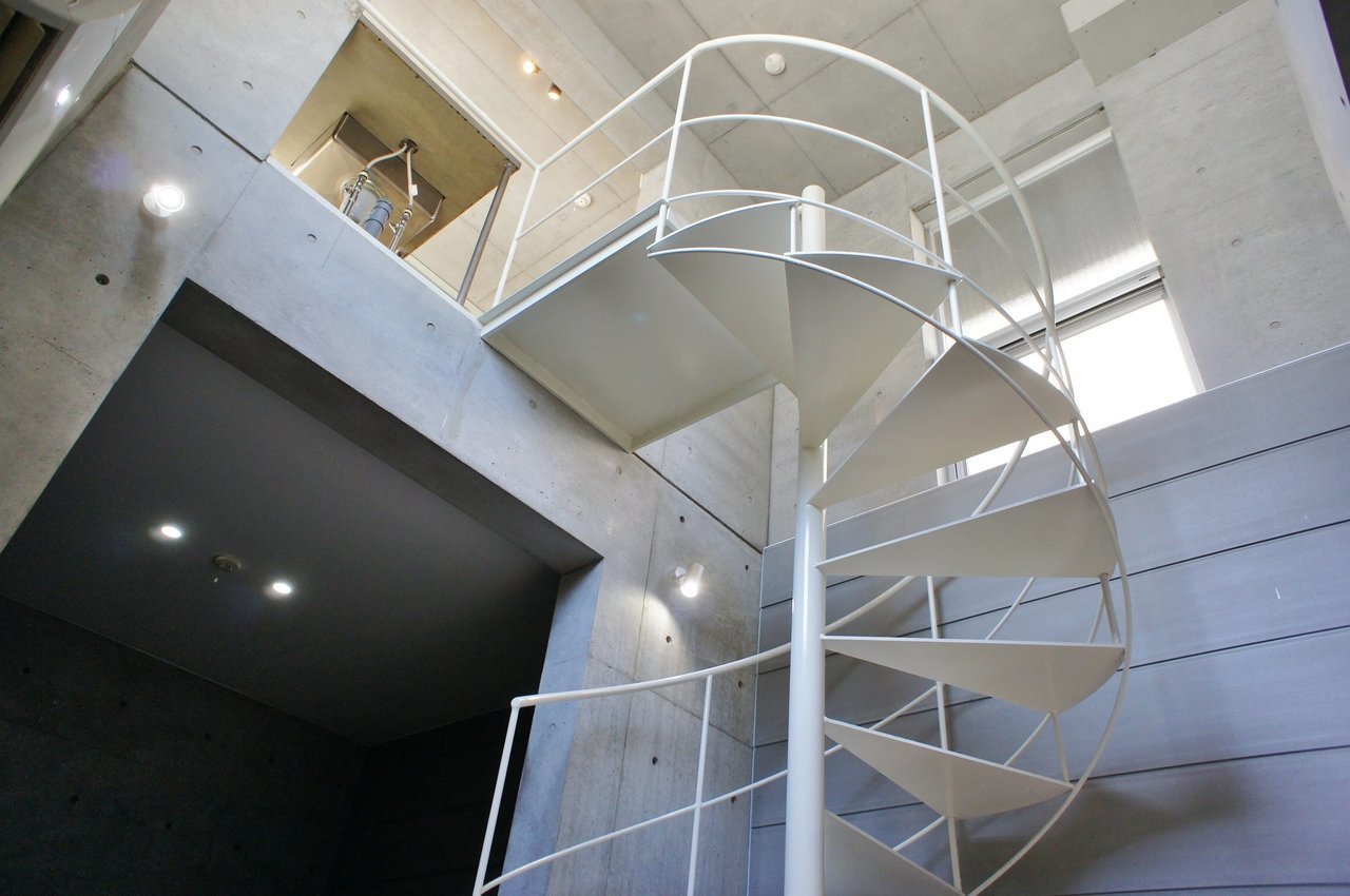 白い螺旋階段が印象的なこちらのお部屋。長い階段だからこそ天井が高い、デザイナーズ物件です。