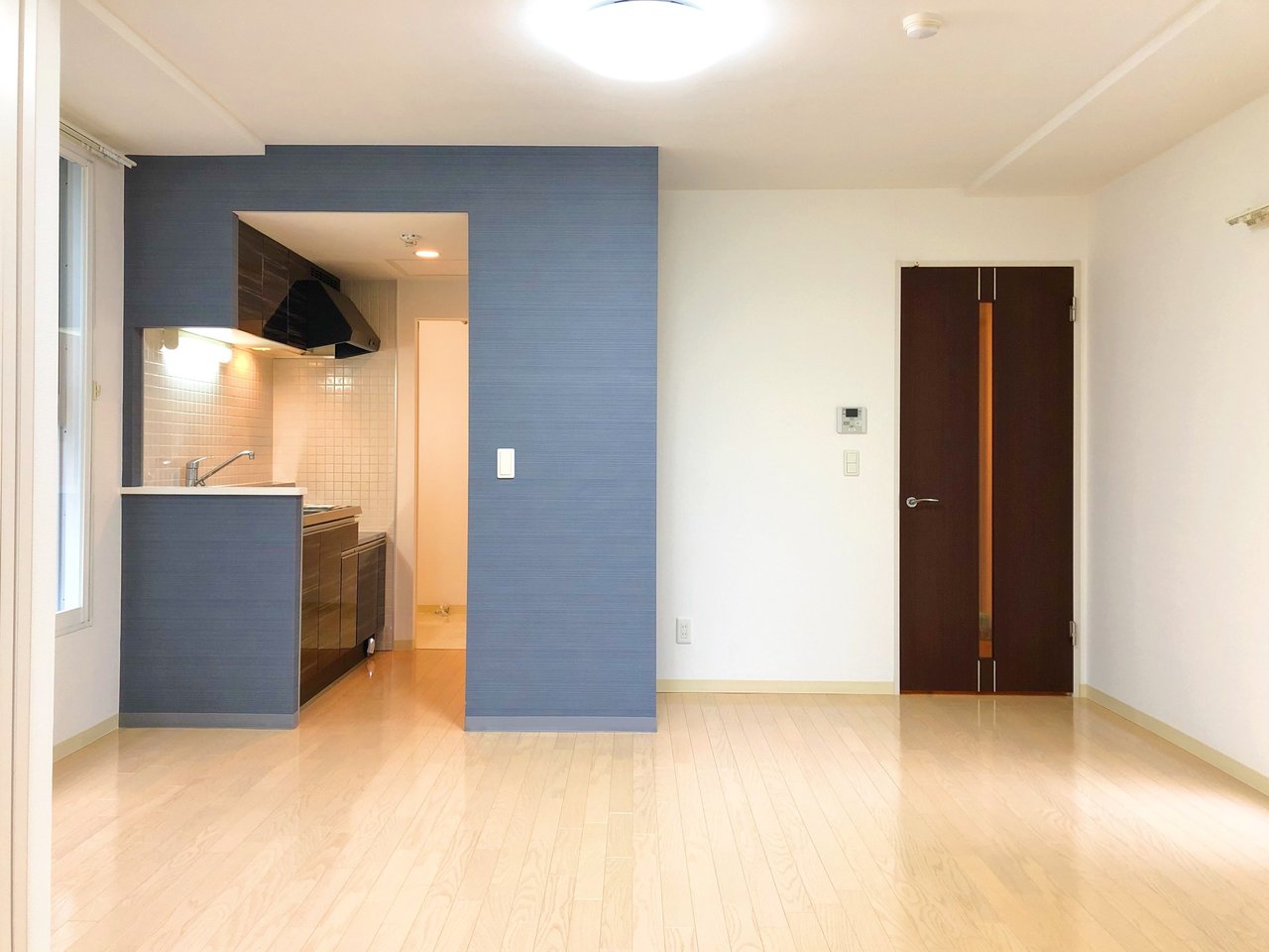 約8畳のリビングと、4.6畳の寝室が、縦に繋がっているタイプの間取り。キッチン横に貼られた淡いブルーのクロスが、お部屋のアクセントになりますね。