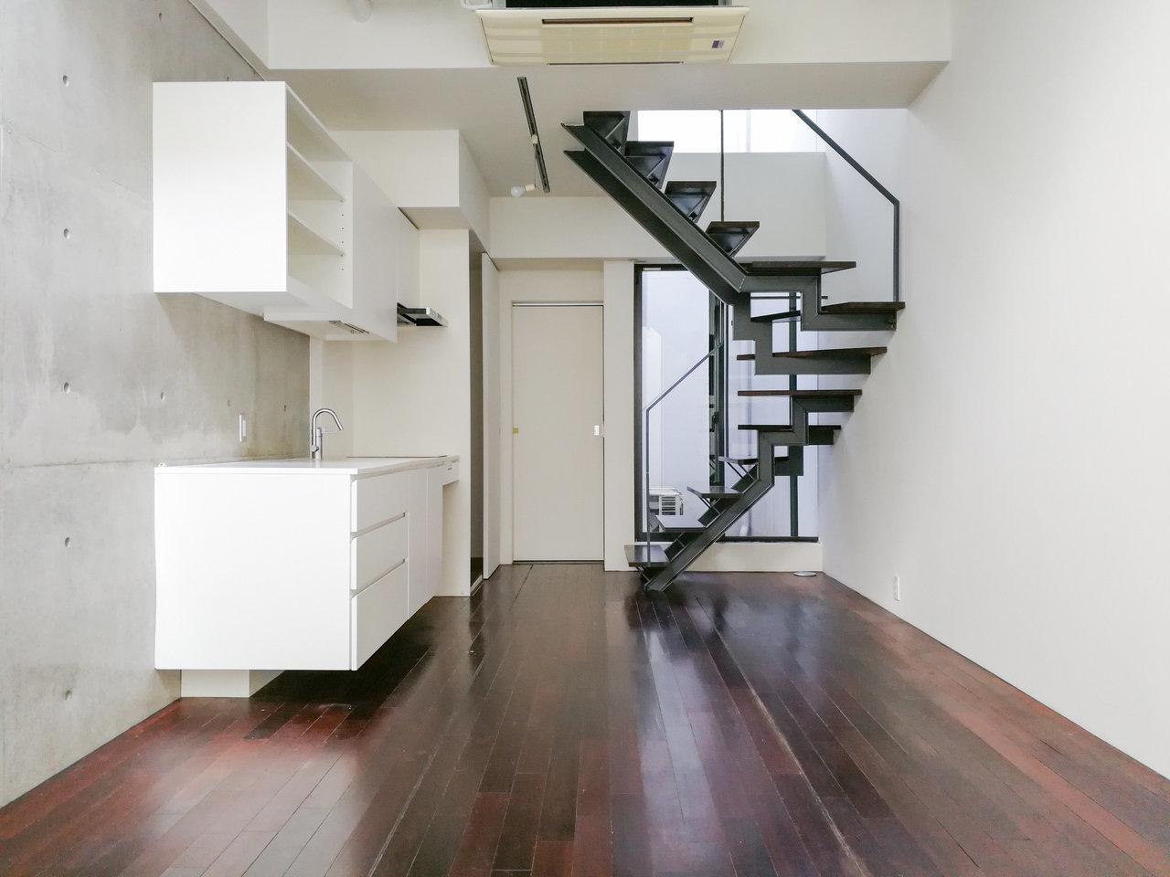 視界の抜け感も楽しめるシックな階段。真っ白なキッチンとのコントラストが美しい……。