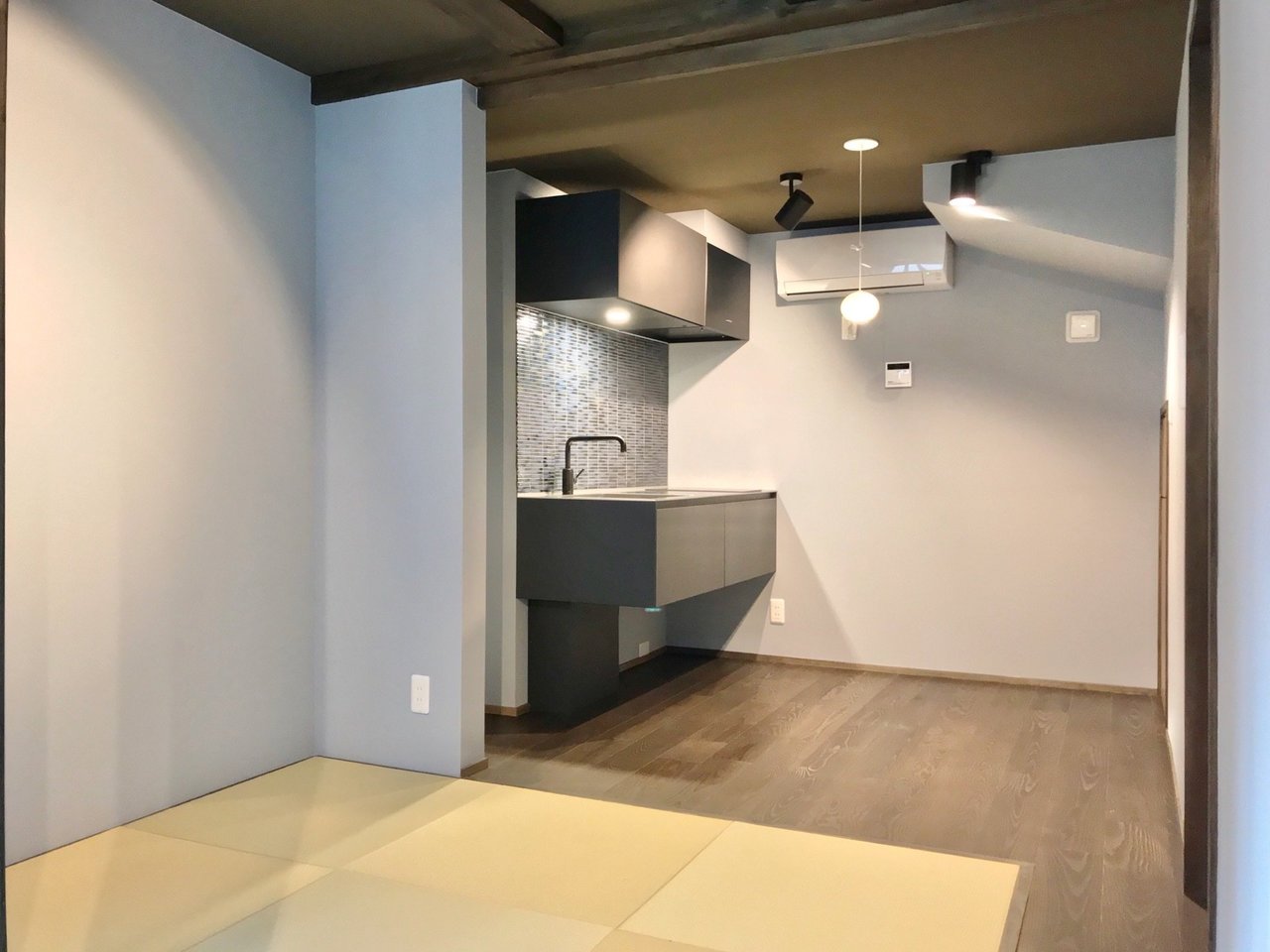 博多駅徒歩13分の便利な場所に誕生した和モダンな長屋。1階には琉球畳でくつろげるスペース。文机を置いて、文豪気分で仕事するのも良さそうです。