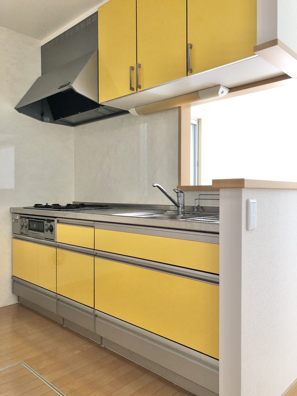 キッチンの内側は鮮やかな黄色。上下に収納たっぷりで、調理器具やお皿をきれいに整頓しておけそうです。