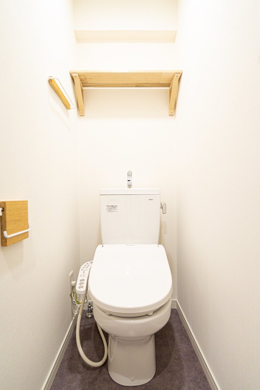 トイレや洗濯機置き場など、様々な場所に無垢の木材を使用した棚が取り付けられています。お部屋の床と合わせて統一感が生まれていますね。