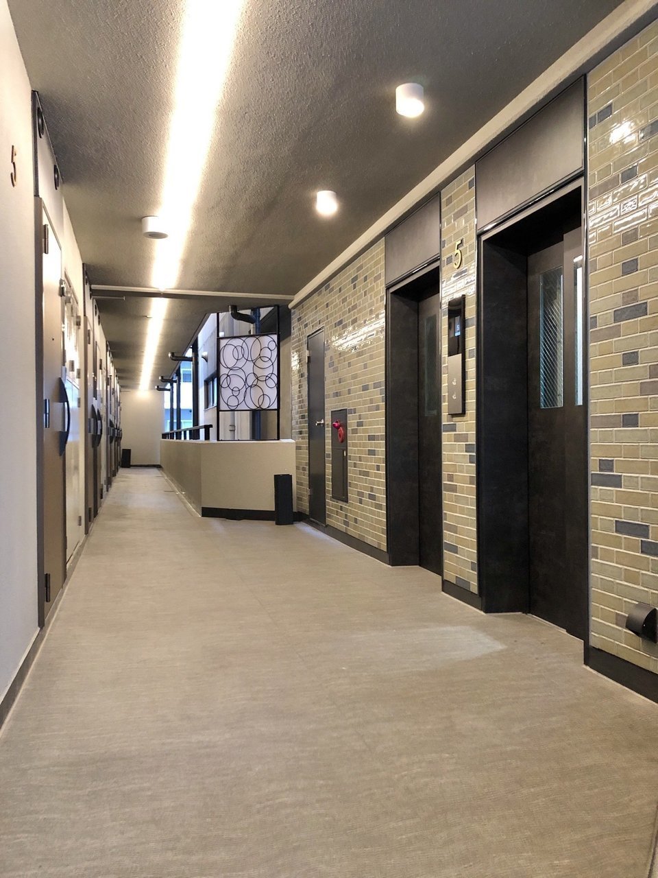 共用廊下は、あえてレトロなタイルを貼り、照明や床も高級感を演出しています。