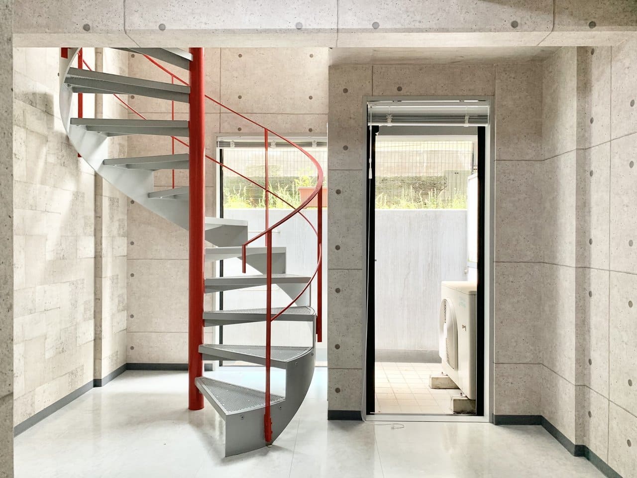 優しい光に照らされる赤。螺旋階段は場所を取らずに空間を繋げられるので、居室を広く活用できるのがポイントです。