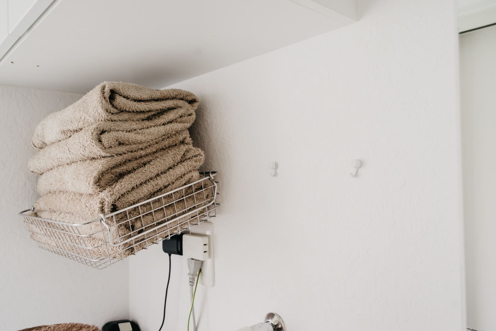 脱衣所に賃貸OKなフックと無印のワイヤーバスケットを組み合わせてタオル置き場に。