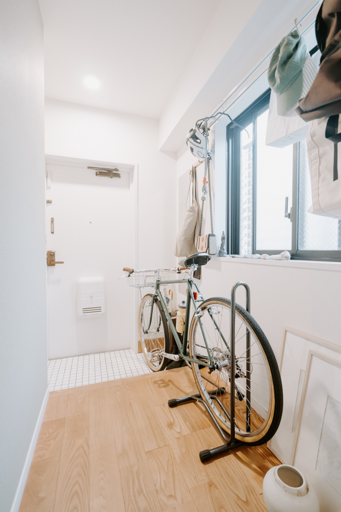 愛用の自転車が置ける広い玄関もお気に入り。カーテンレールやTOMOS備え付けのフックを使って、収納スペースやバッグハンガーなどにしています