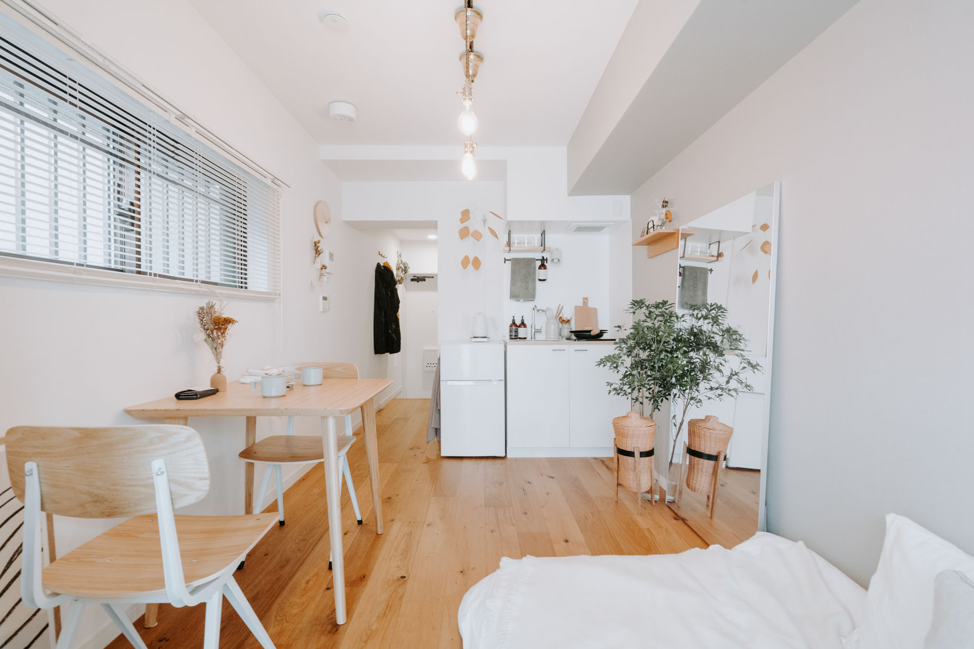 18㎡と小さな空間で二人暮らしをされているお部屋のキッチンでは、高さをぴったり合わせた冷蔵庫の上を作業スペースとして使われていました。冷蔵庫は amadana のもので、デザインも洗練されています。（このお部屋はこちら）