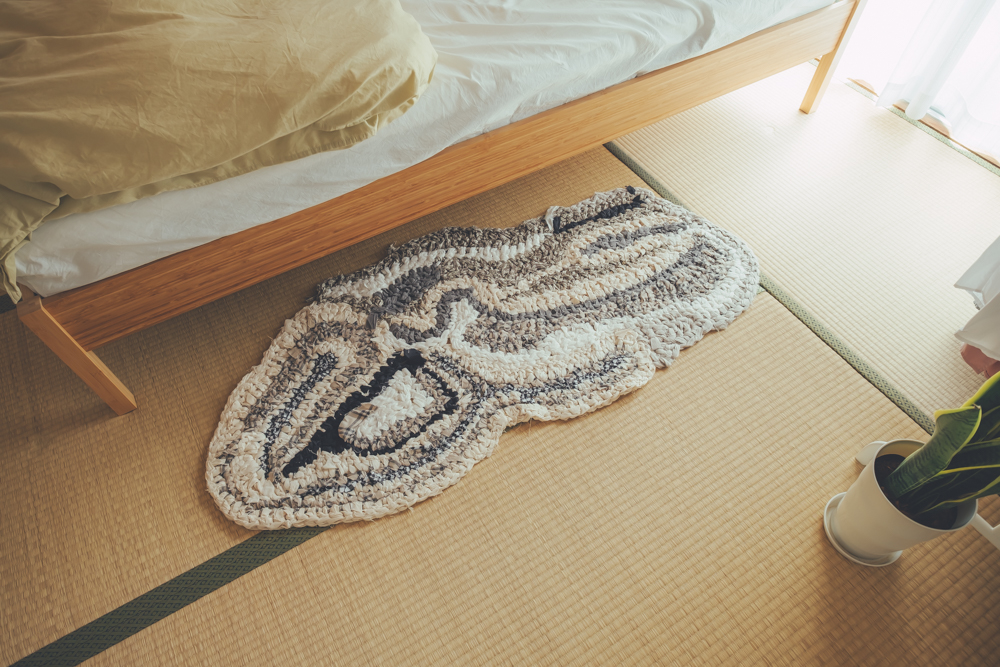 またリビング同様、ベッドにもTomokoさんが作られたという編み物がありました。足元には立体感あるデザインが印象的なラグ。