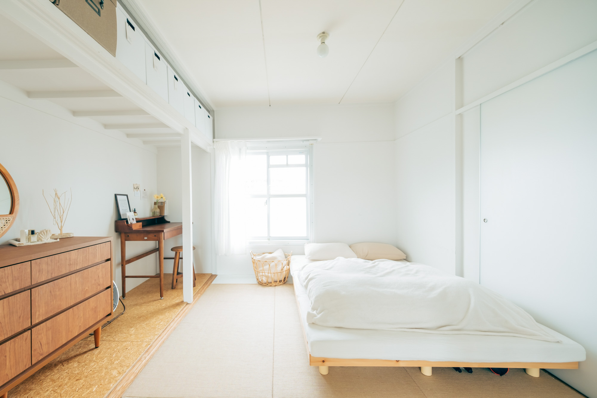 ダイニング・キッチンお隣の麻畳のお部屋にはベッドを置いて、リビング兼ベッドルームとして活用。MUJI×URのお部屋の特徴である、自由に活用できる元押入れのスペースにはワークデスクも置かれています。
