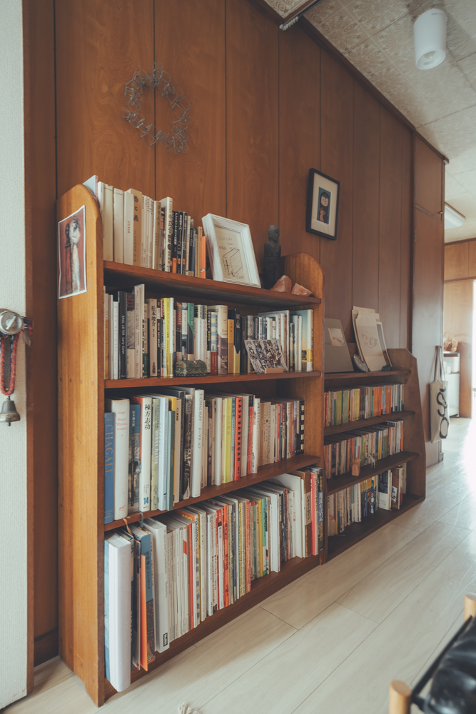 廊下はディスプレイのスペースとしても活用、書籍や美術作品が並んでいます。 「住み初めの頃は何も置いていなかったのですが、暮らしの中で書籍が増えていくのと合わせて、廊下スペースを有効に使おうと考えるようになりました。」