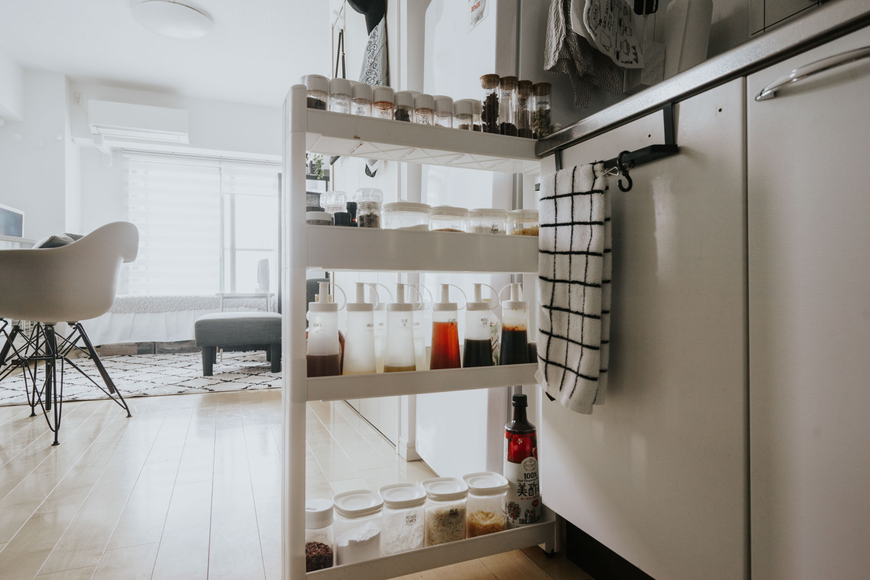 冷蔵庫とキッチンとの間などにスペースがあれば、すきま収納用のラックもおすすめです。こちらのお部屋で使用されているのは、ニトリのスパイスラック。容器もすべて100均で購入した白のケースに入れ替え、統一感を出しています。