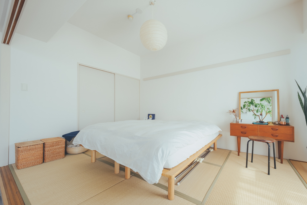 リビングとひと続きの和室は、ホテルライクなベッドルームにされていました。セミシングルを2つ並べたベッドをあえて真ん中に配置して、和モダンな空間を活かしていらっしゃいます。照明はイサムノグチの「AKARI」。