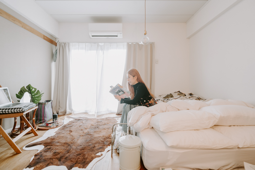 最低限の家具で暮らしているKONOMIさん。寝心地にこだわったダブルサイズのベッドをどん、と置いて、ゆったりと使われています。ベッドは腰掛けてソファがわりにも。