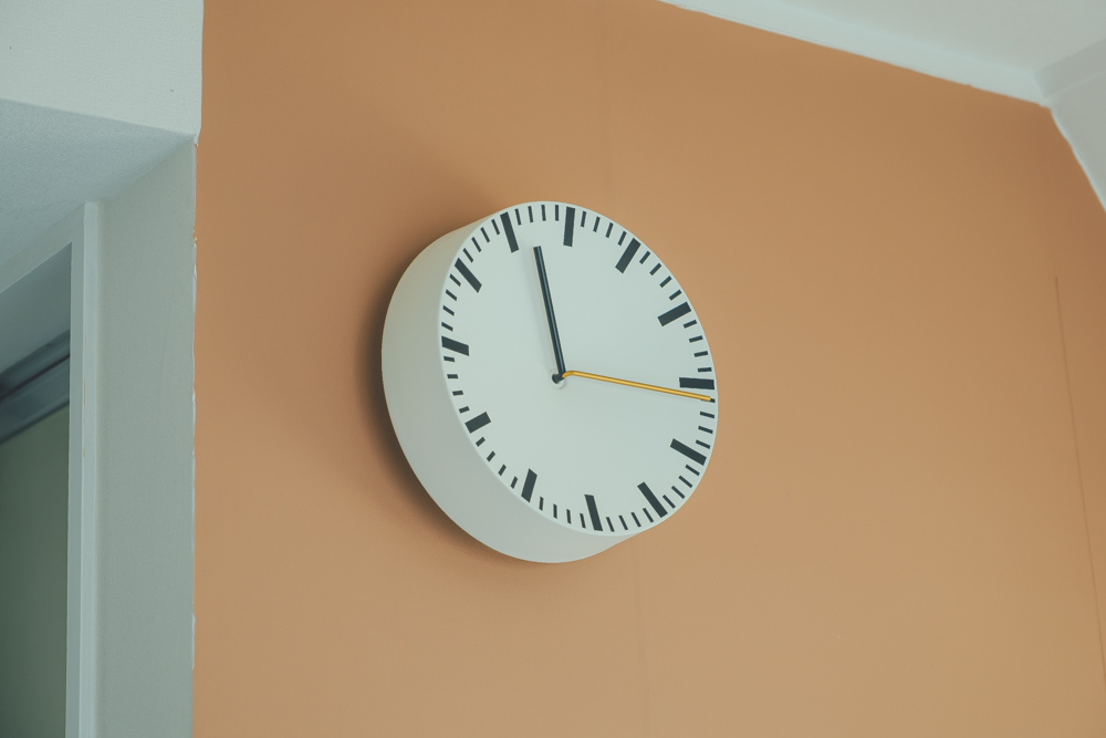 テラコッタの壁紙に映える時計は、HAYのもの。中央がくぼんだような他にはないデザインがお気に入り。スチール製でとても軽く扱いやすいのだそう。（このお部屋はこちら）