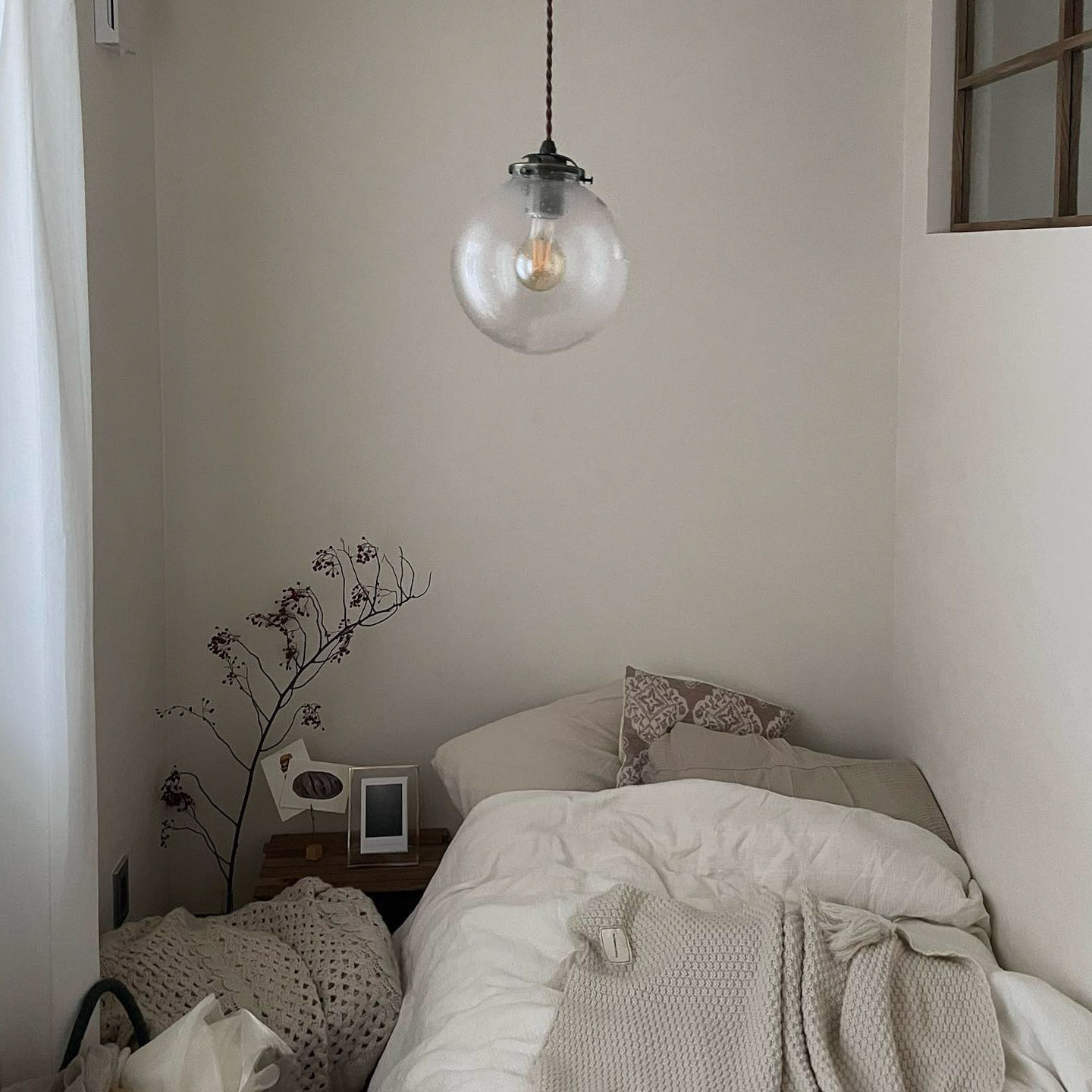 シングルベッドがちょうどおさまったという寝室は色を統一してシンプルな空間に。照明は気泡が入った感じが気に入ってリサイクルショップで購入したもの。「照明を変えるだけでも、部屋の雰囲気はかなり変わるので、おすすめです」
